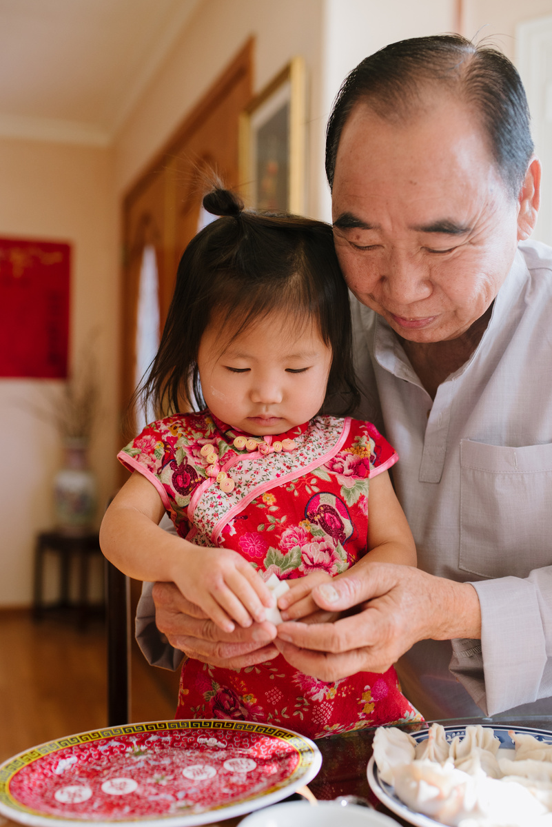 Grandfather Helping Granddaughter Making Dumplings